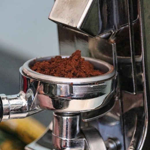best coffee shops in san francisco downtown 咖啡师在旧金山市中心小店吧台前称豆研磨，电子秤与手冲壶并排摆放，暖色灯光下的专注动作特写